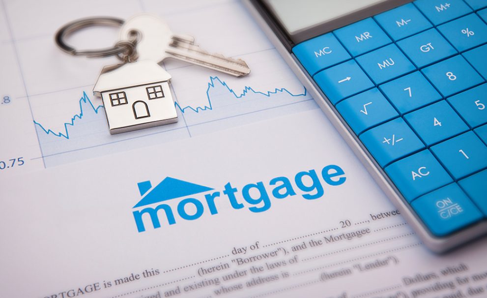 House keys and a calculator on top of mortgage papers